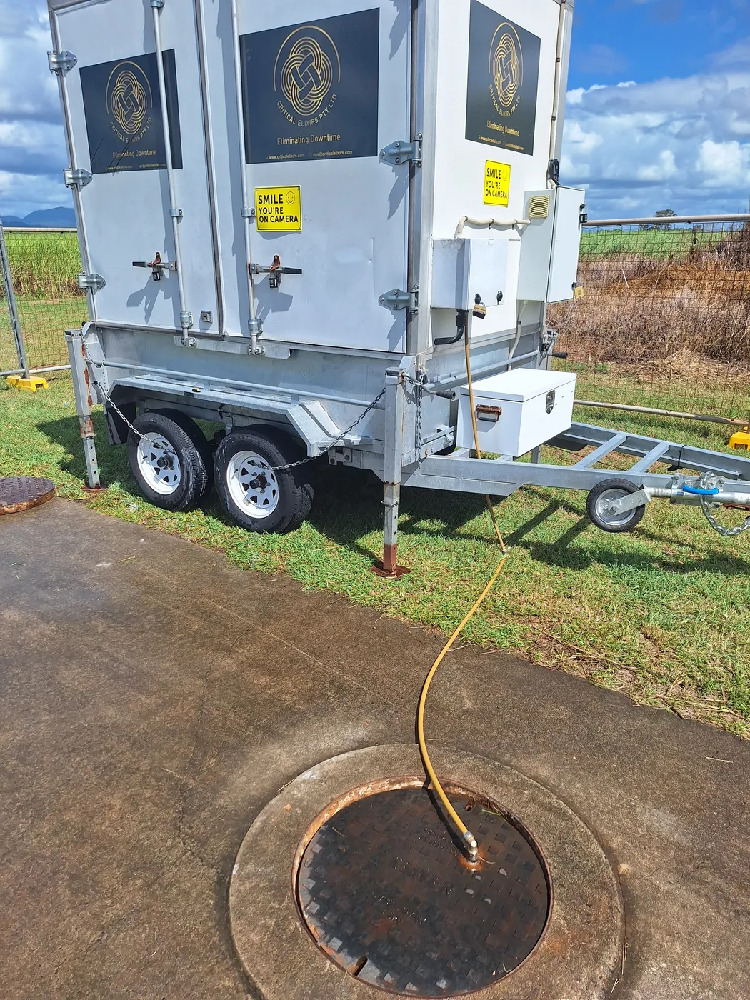 Dosing trailer with a hose running into a sewer access cover